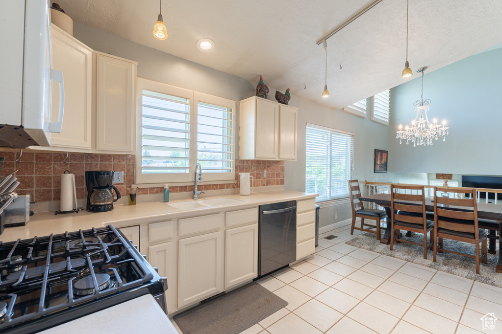 Kitchen with dishwasher, a sink, white microwave, light tile patterned floors, and black gas range oven