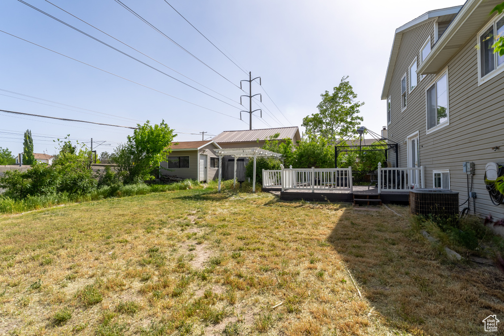View of grassy yard with cooling unit, a wooden deck, and a gazebo