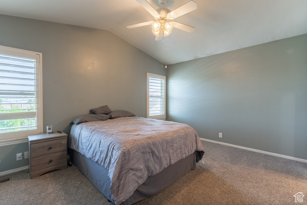 Bedroom featuring carpet, vaulted ceiling, baseboards, and a ceiling fan