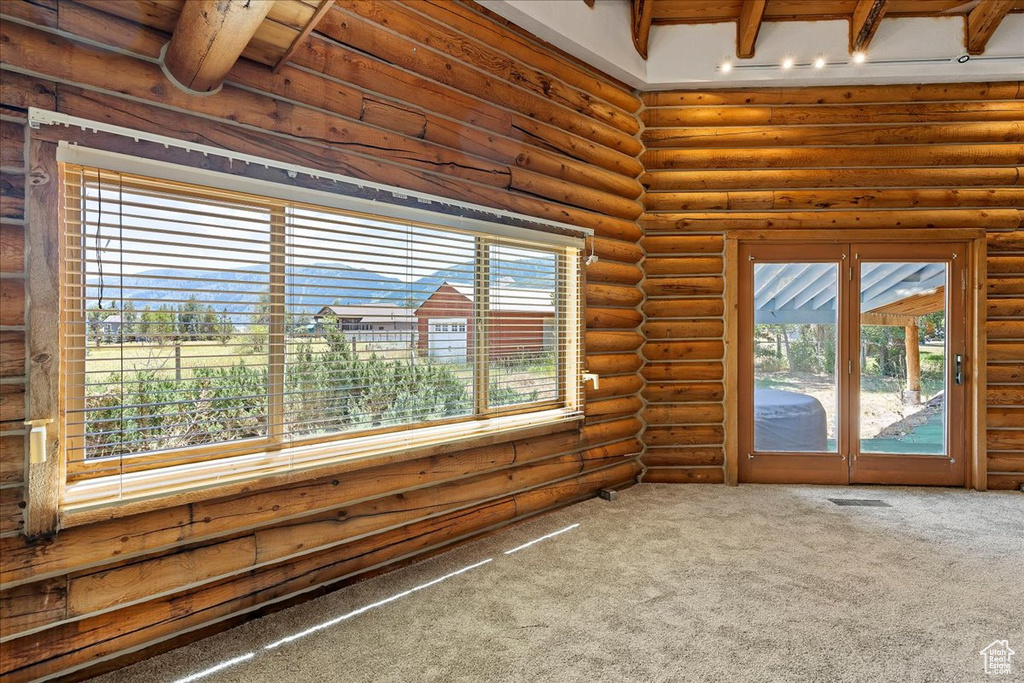 Unfurnished sunroom featuring beamed ceiling and french doors