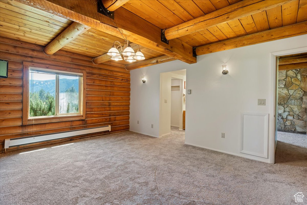 Carpeted spare room with baseboard heating, wooden ceiling, beamed ceiling, log walls, and a chandelier