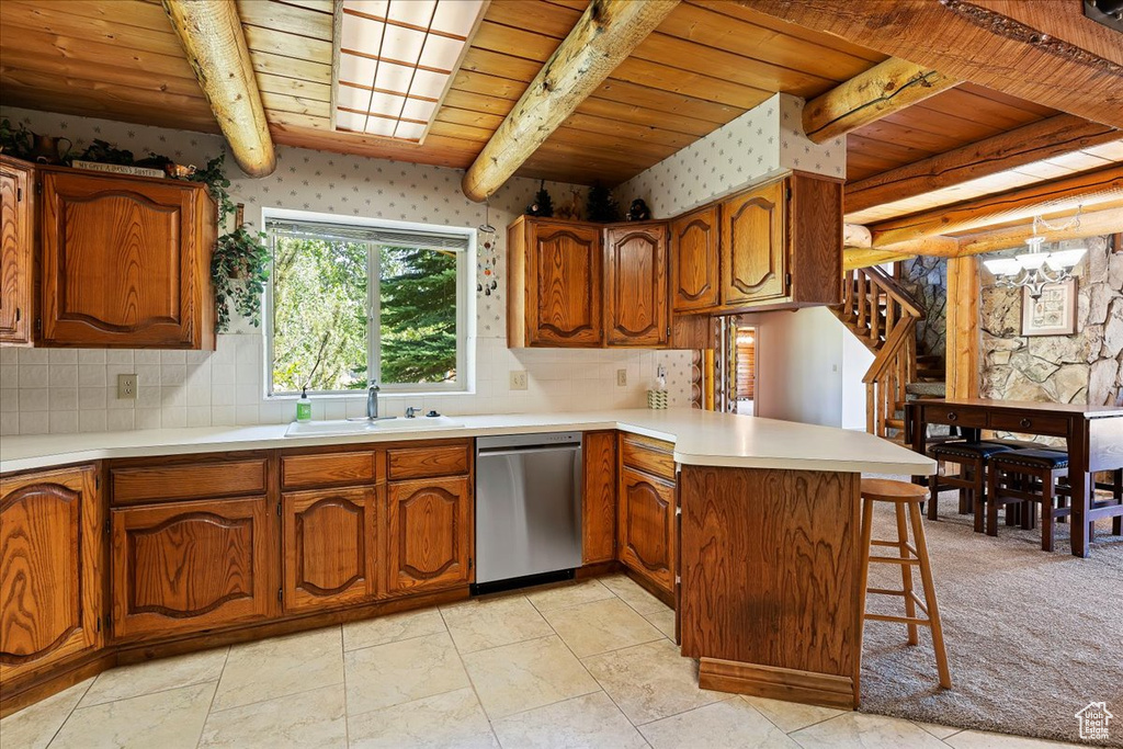 Kitchen featuring stainless steel dishwasher, a sink, a peninsula, wooden ceiling, and brown cabinets