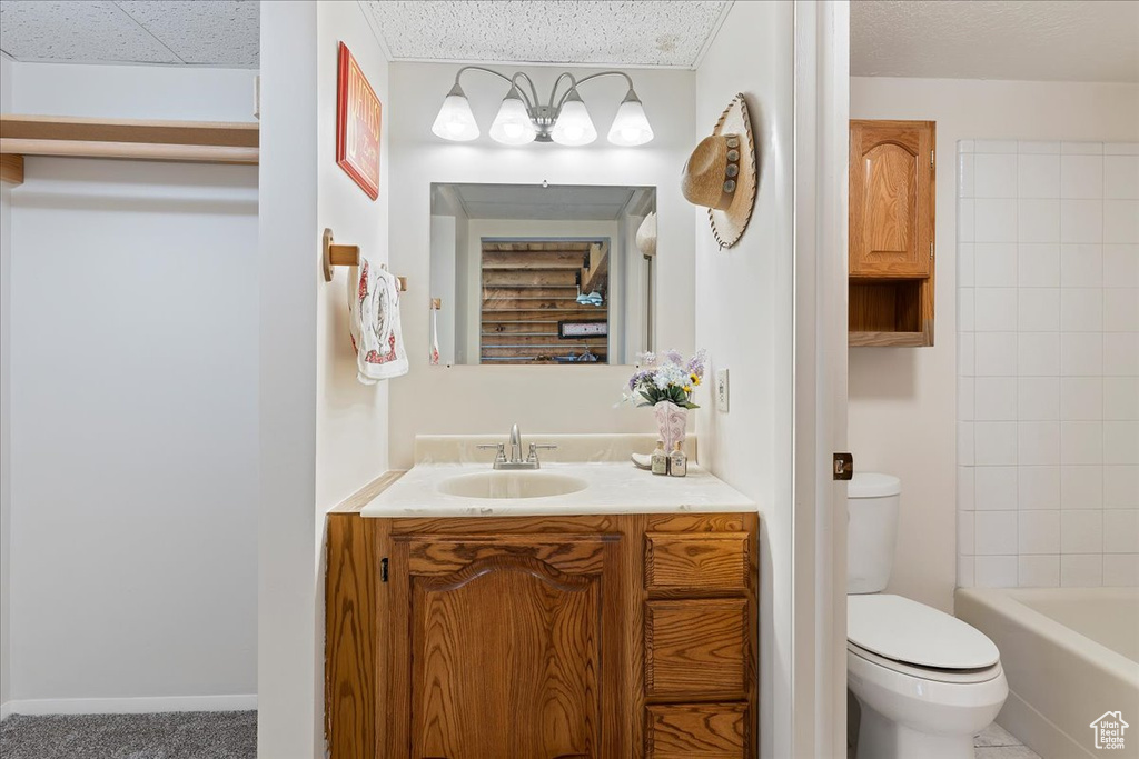 Full bath with toilet, vanity, and a textured ceiling