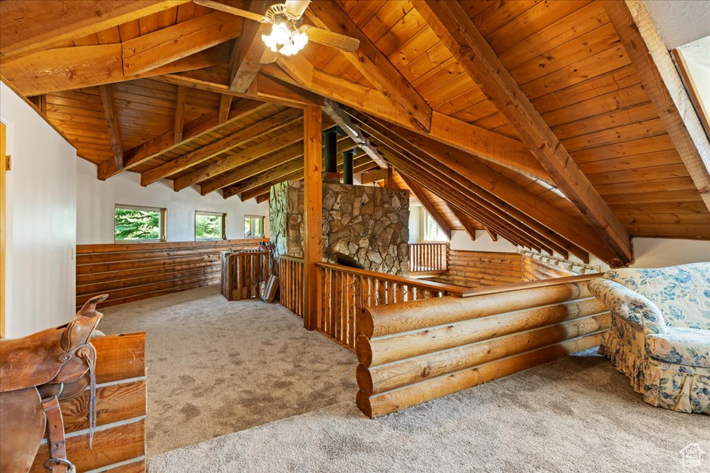 Additional living space featuring carpet, wood ceiling, a ceiling fan, and rustic walls