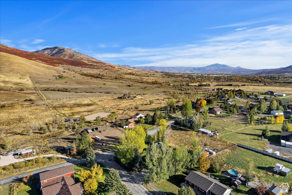 Aerial overview of property's location with a mountain backdrop and nearby suburban area