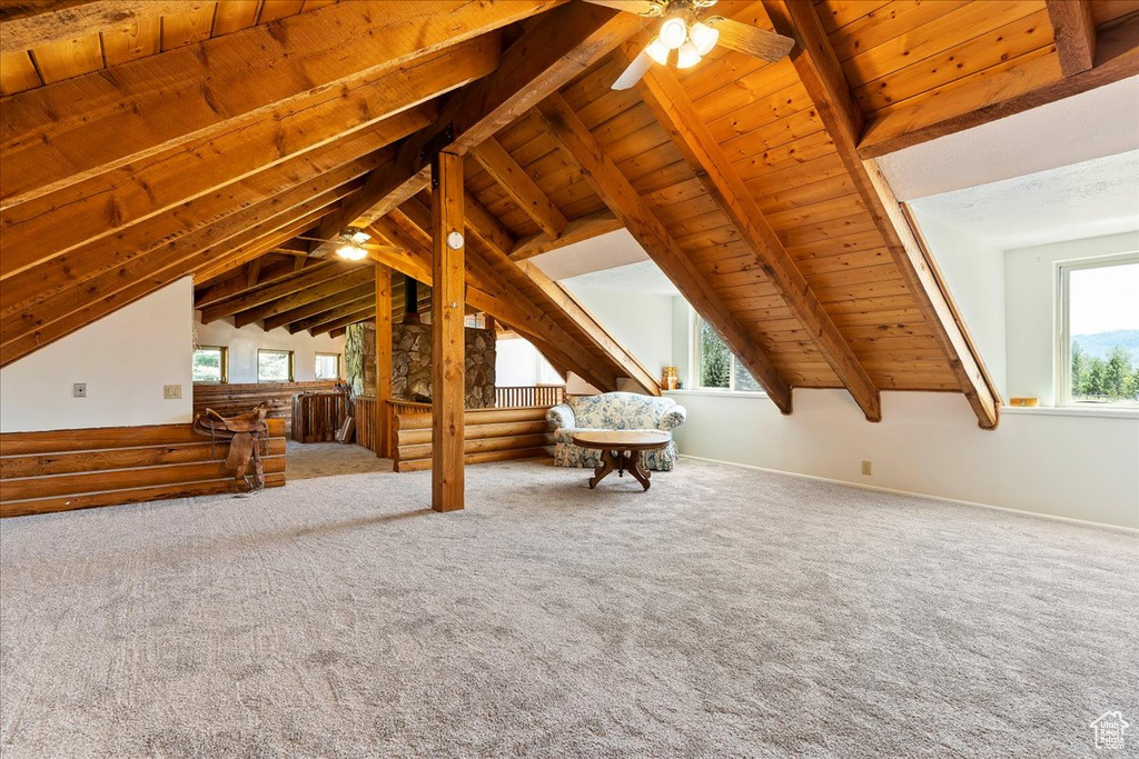 Unfurnished living room featuring ceiling fan, wooden ceiling, and carpet flooring