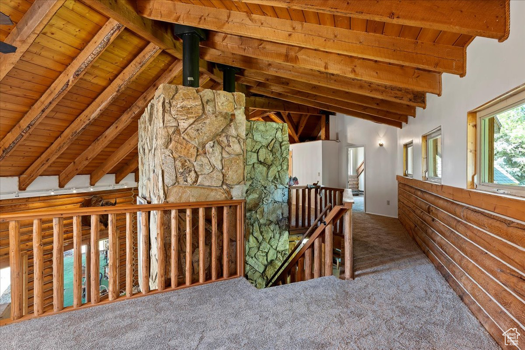 Hallway featuring an upstairs landing, wood ceiling, and carpet floors