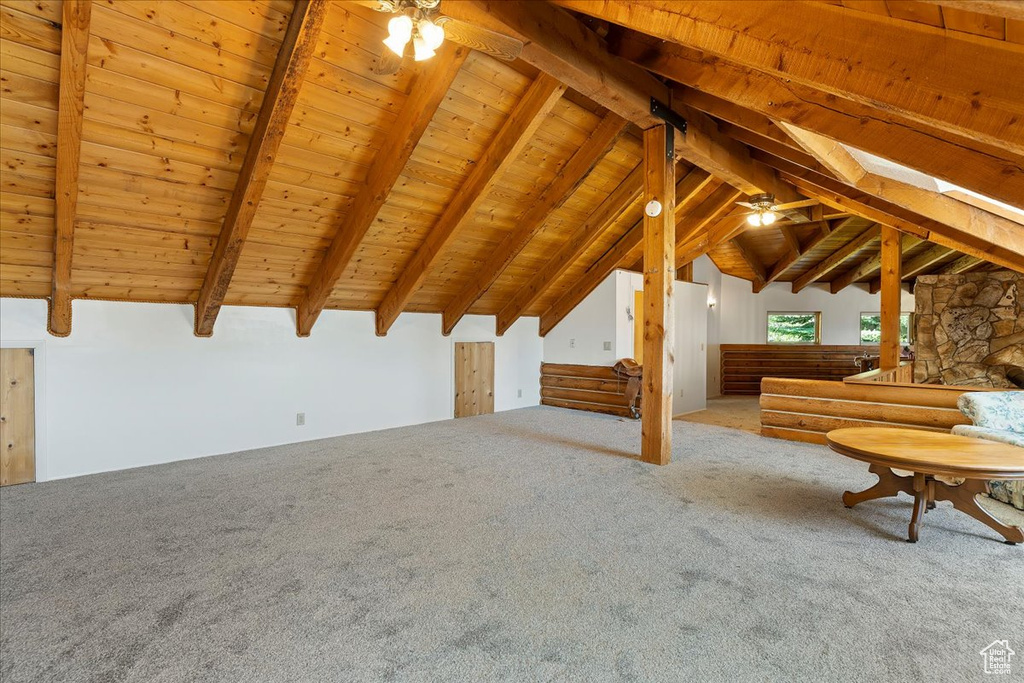 Unfurnished living room featuring carpet flooring, a ceiling fan, and wooden ceiling