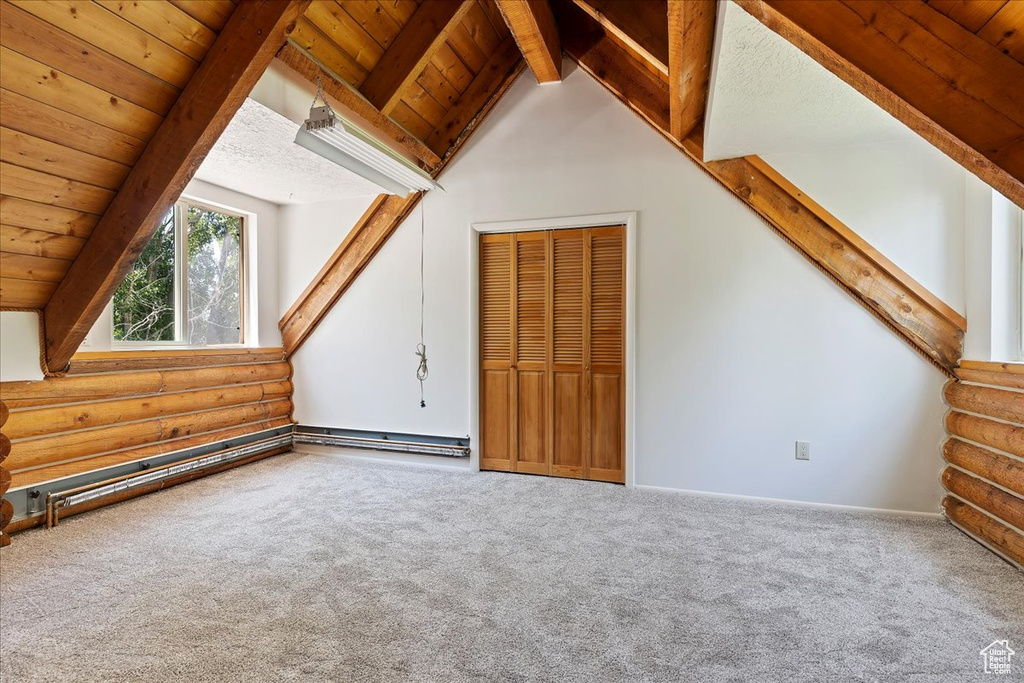 Bonus room featuring carpet, log walls, wood ceiling, and baseboards
