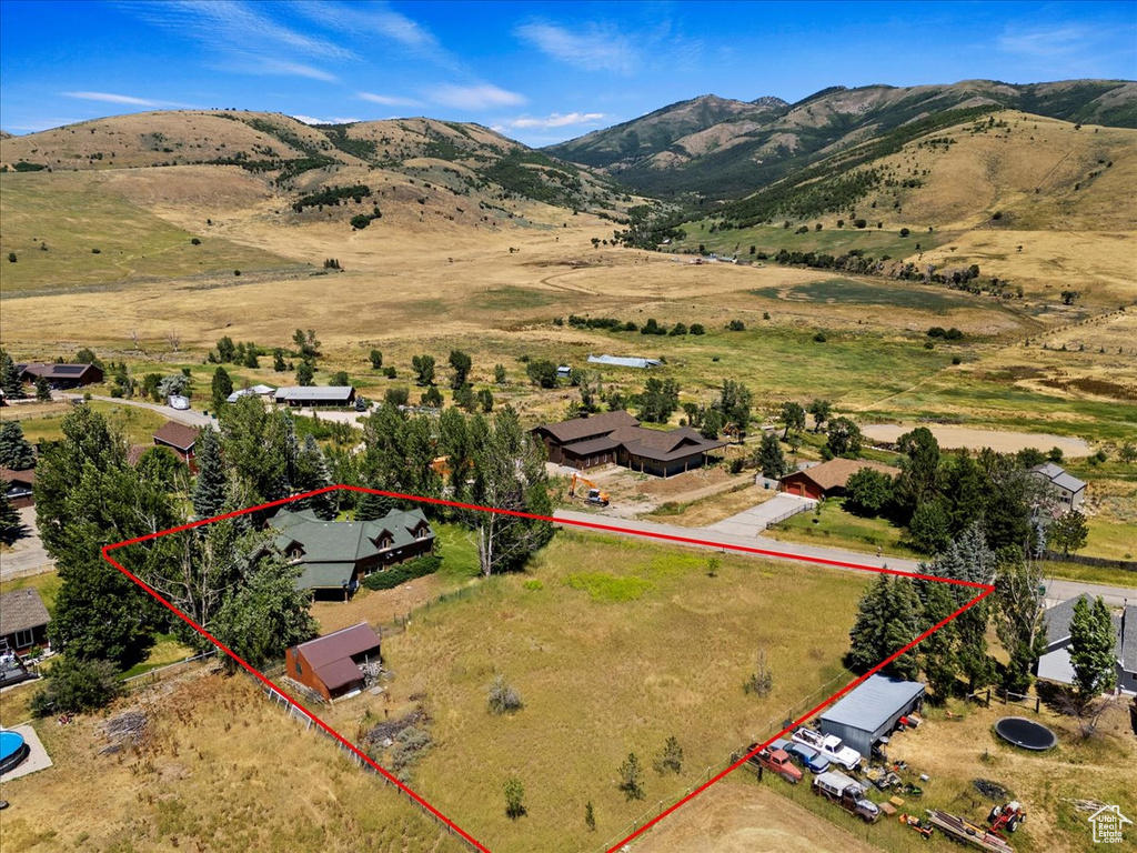 Aerial overview of property's location featuring property boundaries highlighted and a mountain backdrop