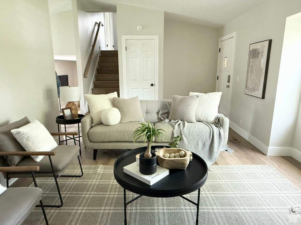 Living room featuring wood finished floors, baseboards, and stairs