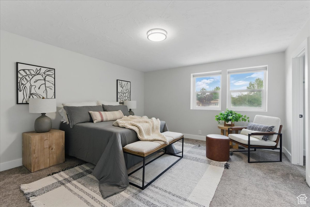 Bedroom featuring carpet and baseboards
