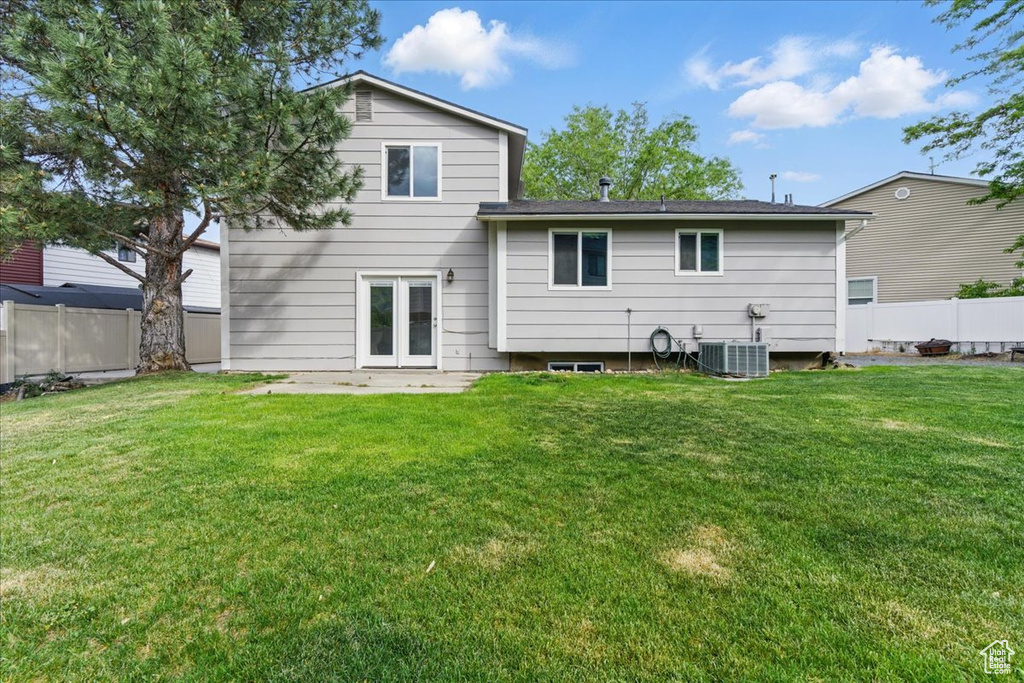 Back of property with central AC unit and a patio area