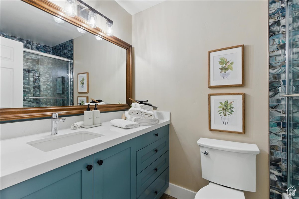 Full bathroom featuring a shower stall, vanity, and toilet