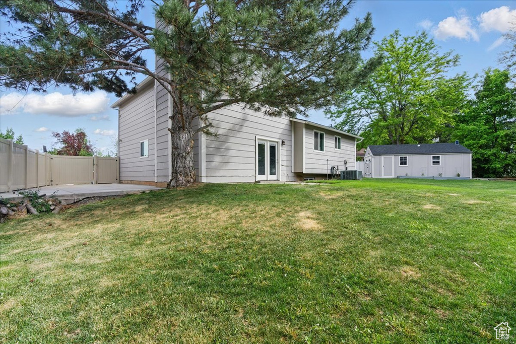 Back of house featuring french doors, cooling unit, a gate, and a patio area