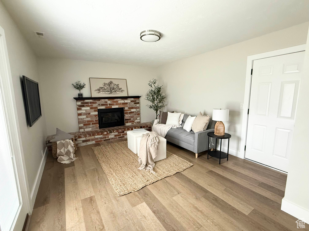 Living area with wood finished floors, baseboards, and a fireplace