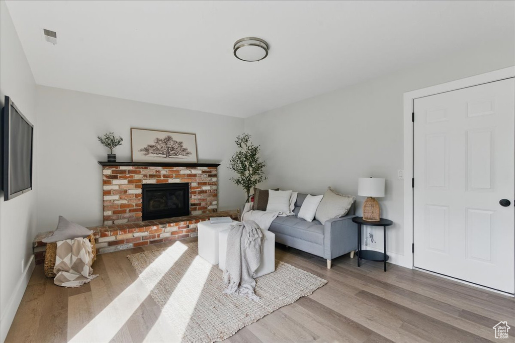 Living area featuring wood finished floors, baseboards, and a fireplace
