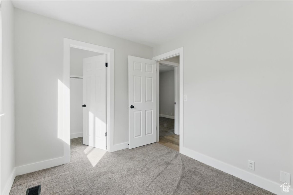 Unfurnished bedroom featuring carpet floors and baseboards