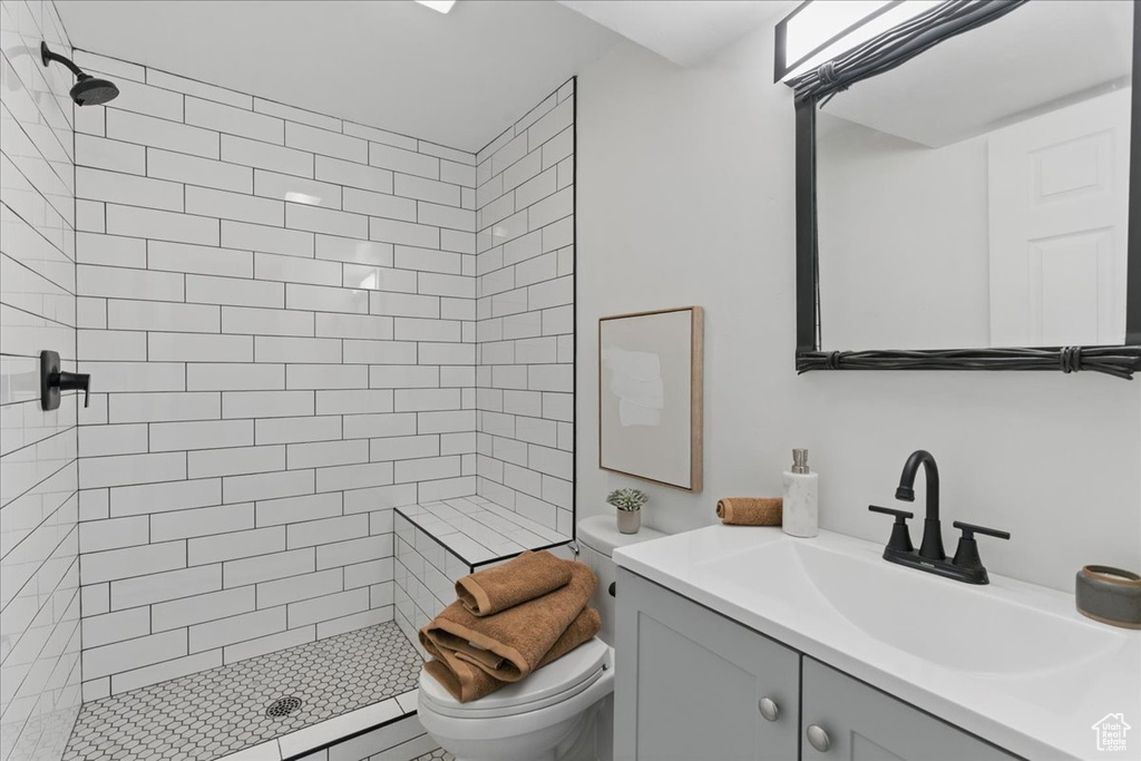 Bathroom with toilet, a shower stall, and vanity