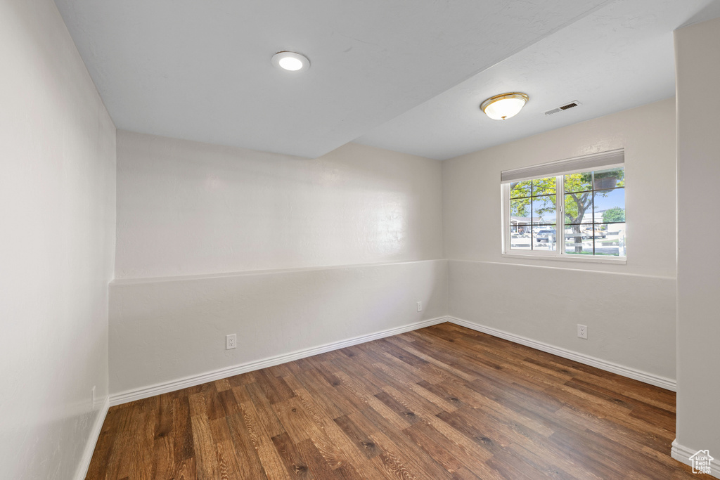 Empty room with dark wood finished floors and baseboards