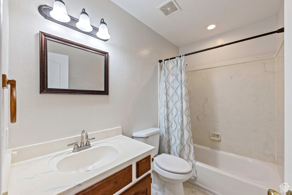 Bathroom featuring toilet, vanity, shower / bath combination with curtain, and recessed lighting