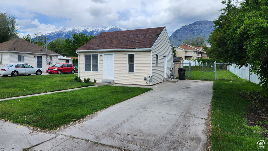 View of front of home featuring a mountain view, driveway, and roof with shingles