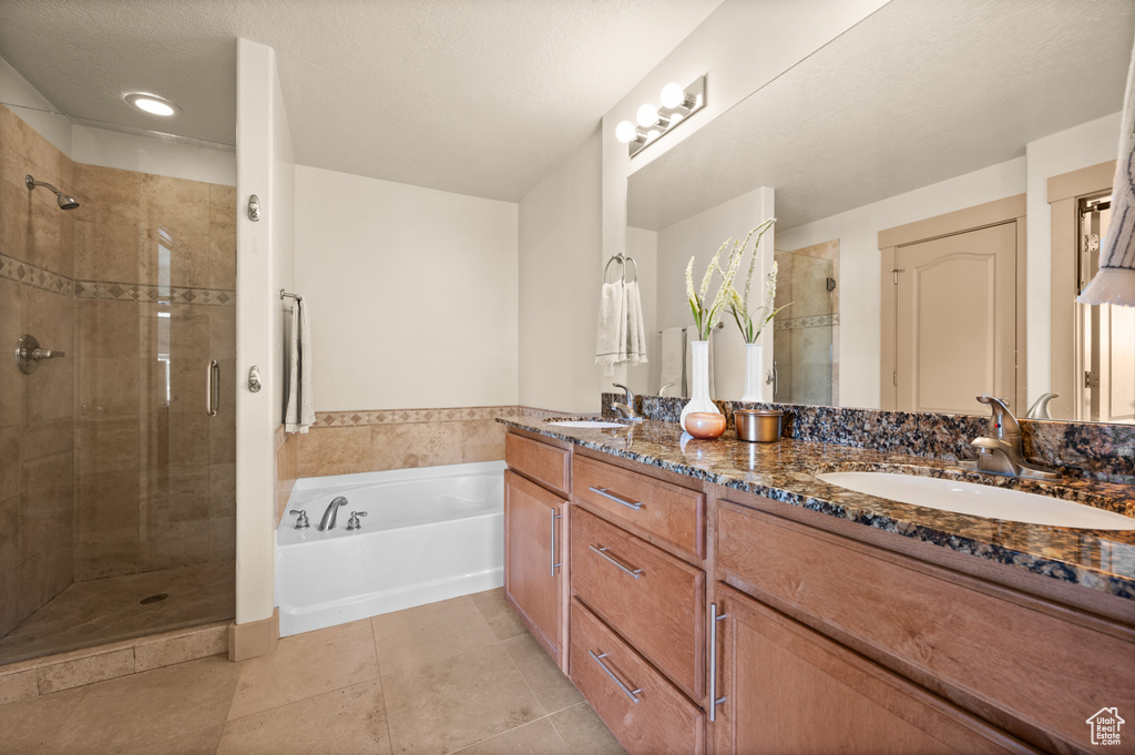 Bathroom with a stall shower, a bath, tile patterned flooring, and double vanity