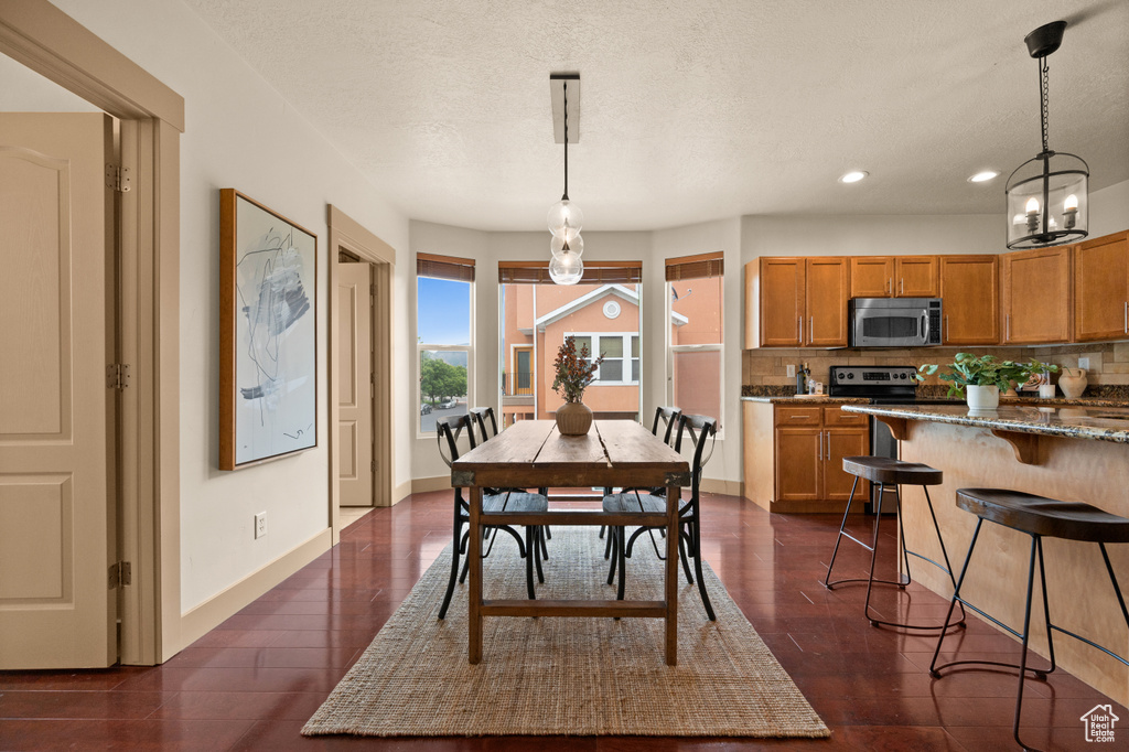 Dining area featuring recessed lighting, baseboards, dark wood-style flooring, and a chandelier