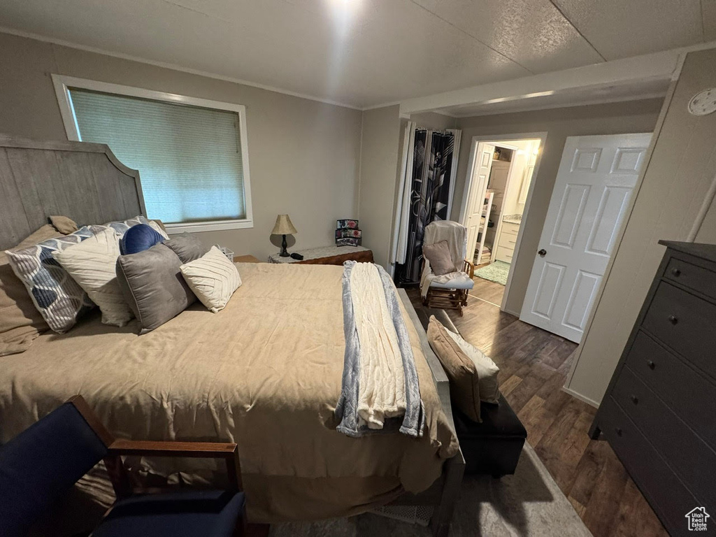 Bedroom featuring dark wood-style floors and ornamental molding
