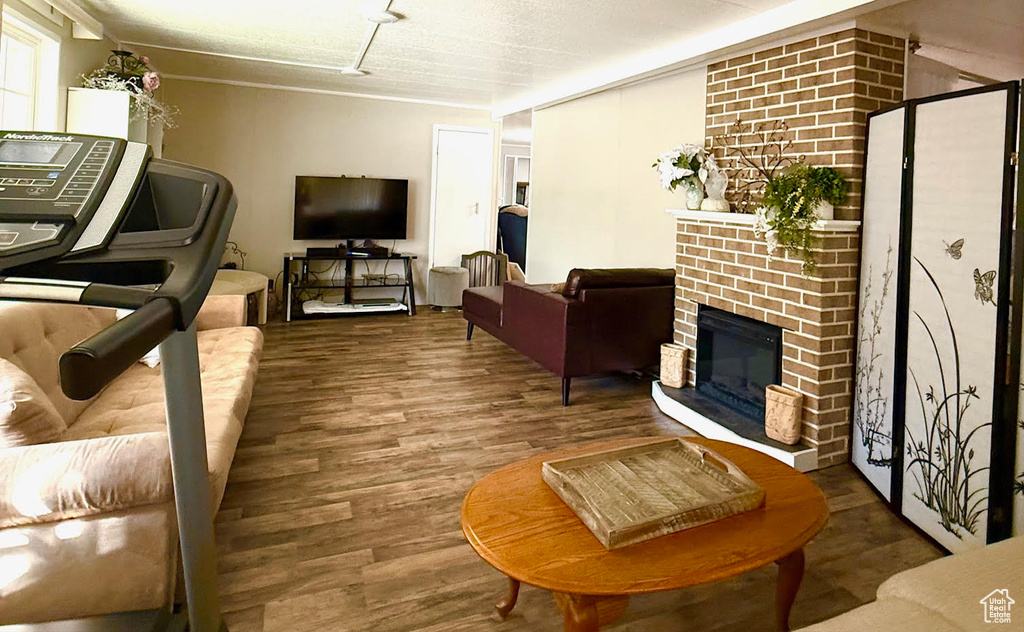Living room featuring wood finished floors and a brick fireplace