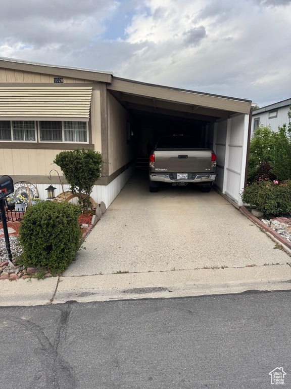 View of front facade featuring a carport and concrete driveway