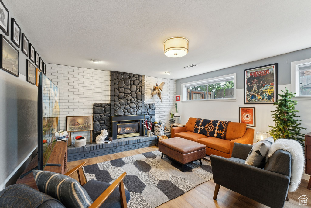 Living room featuring wood finished floors and a brick fireplace