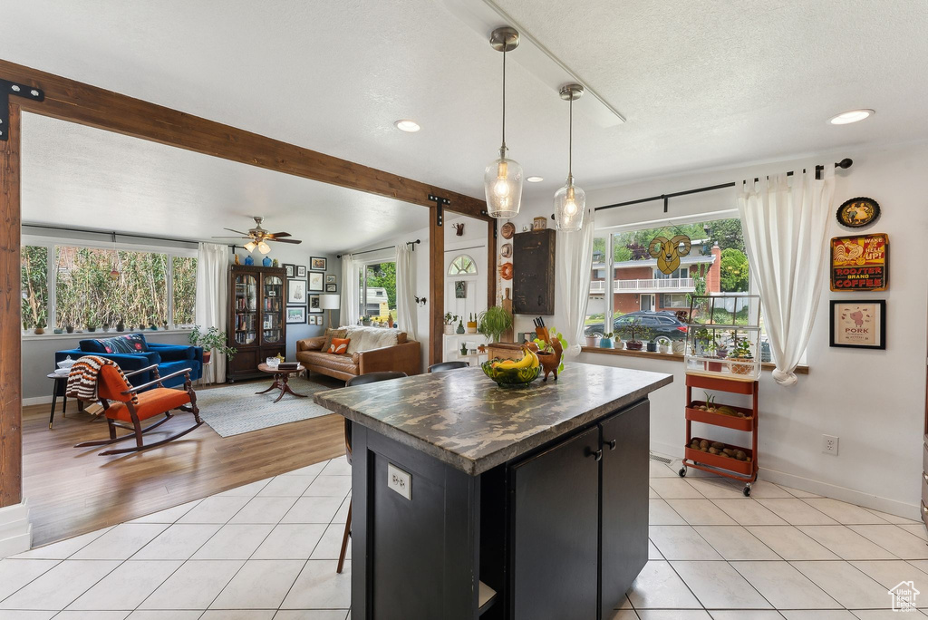 Kitchen featuring light tile patterned flooring, recessed lighting, dark cabinets, pendant lighting, and a ceiling fan