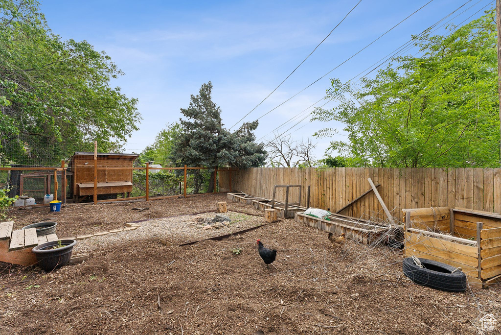 View of yard featuring fence and exterior structure