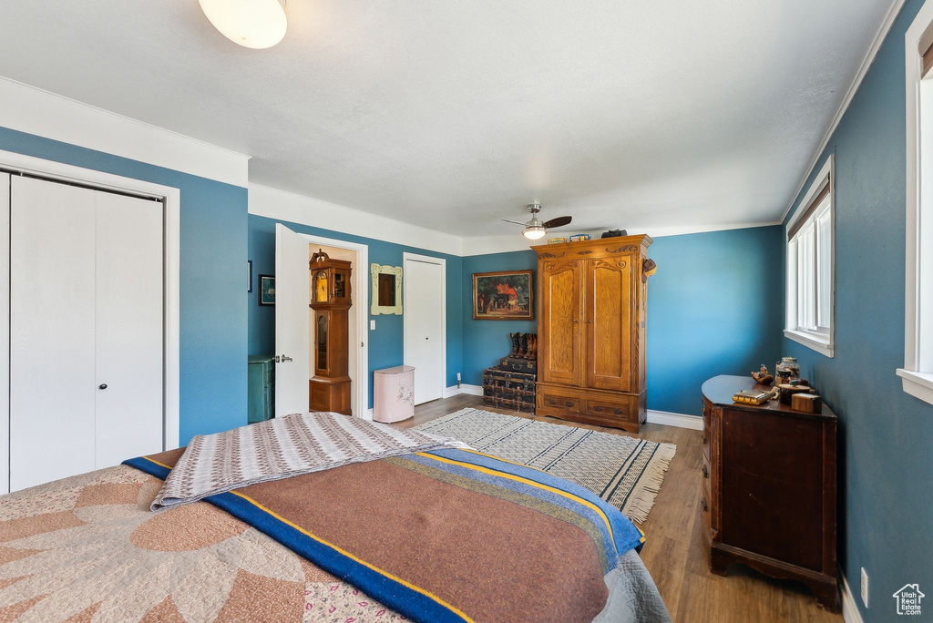 Bedroom with wood finished floors, a closet, baseboards, and a ceiling fan