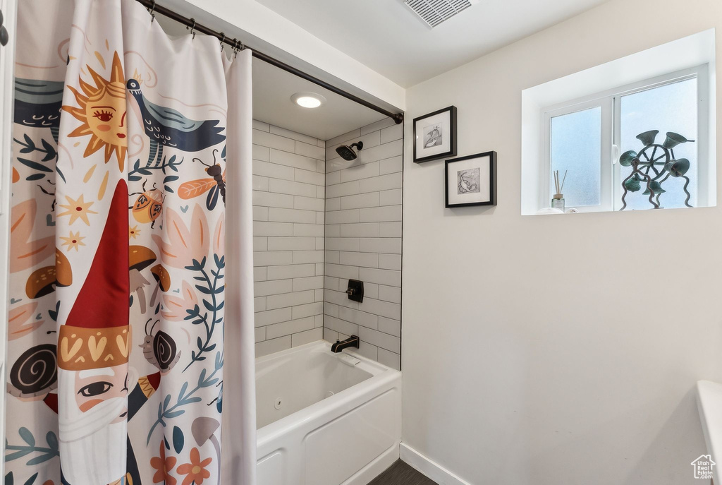 Full bathroom featuring baseboards and shower / bath combo with shower curtain
