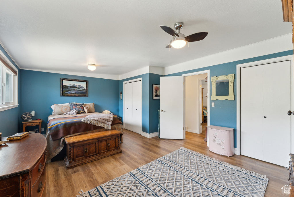 Bedroom with wood finished floors, a closet, ceiling fan, and baseboards