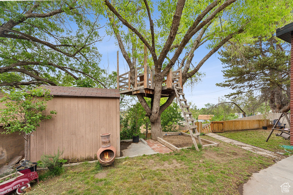 View of yard featuring a shed, an outdoor structure, and a garden