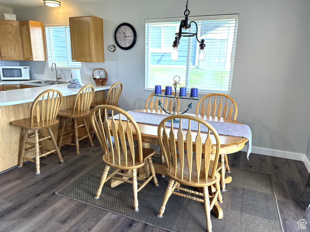 Dining area featuring dark wood-type flooring and baseboards