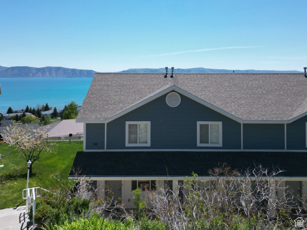 Exterior space with a shingled roof and a mountain view