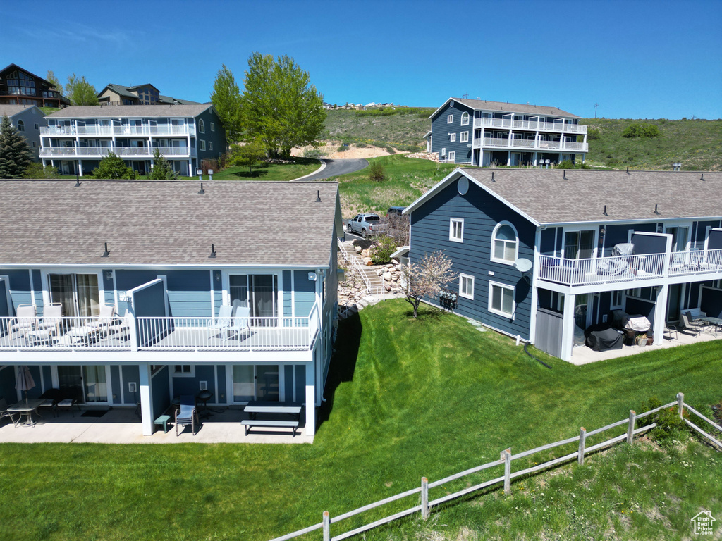Rear view of property featuring a patio and a shingled roof