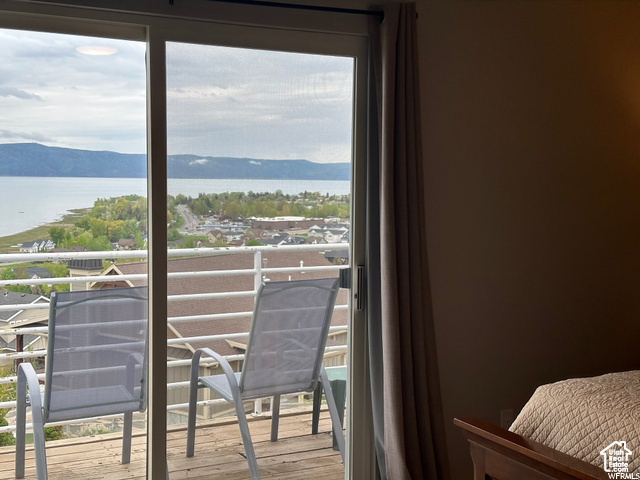 Balcony featuring a water and mountain view