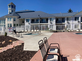 Community pool featuring a patio and fence