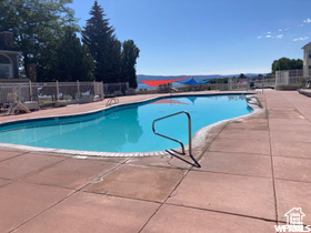 Community pool with a patio and fence