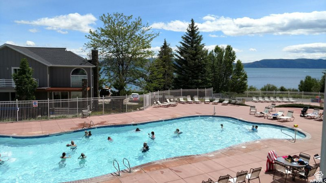 Community pool featuring fence, a mountain view, and a patio area
