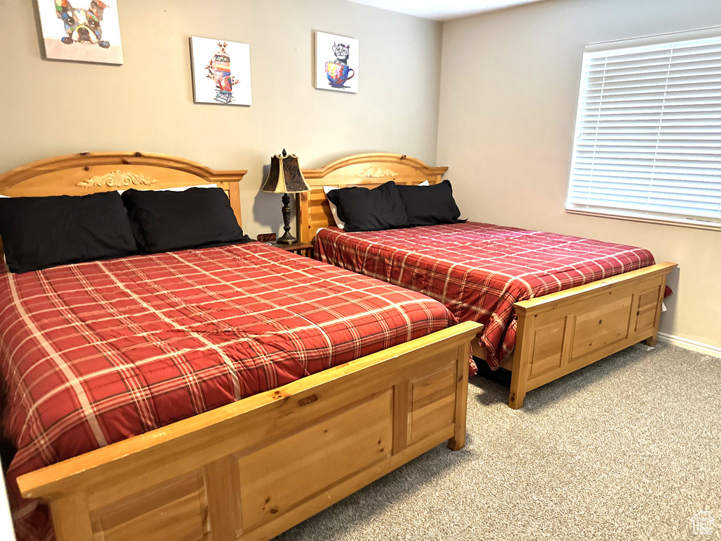 Bedroom with light colored carpet and baseboards