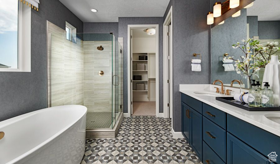 Full bathroom featuring healthy amount of natural light, a stall shower, a freestanding bath, and double vanity