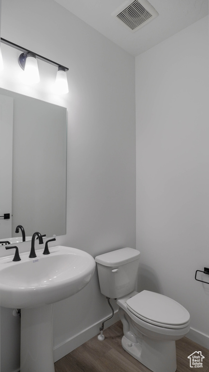 Bathroom with wood finished floors and toilet