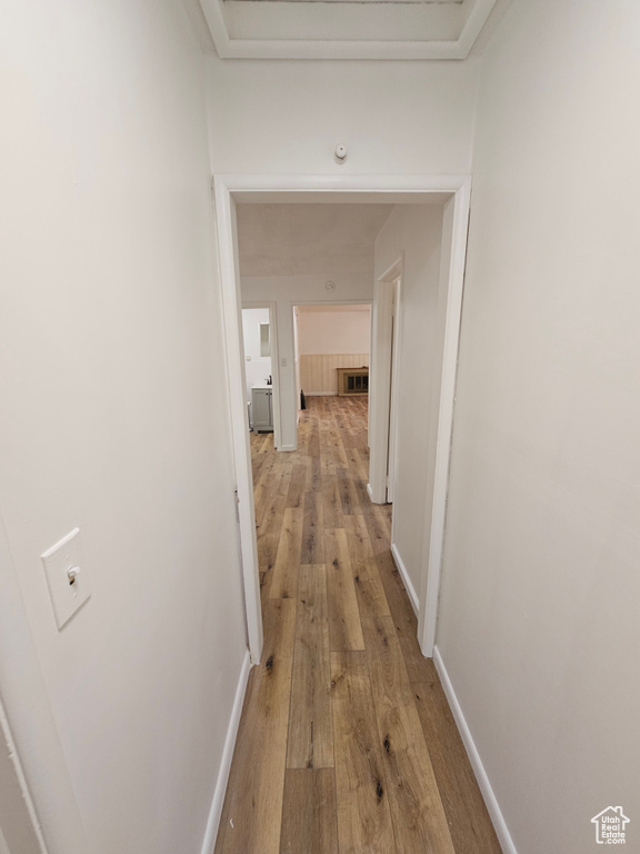 Hallway featuring light wood-type flooring and baseboards