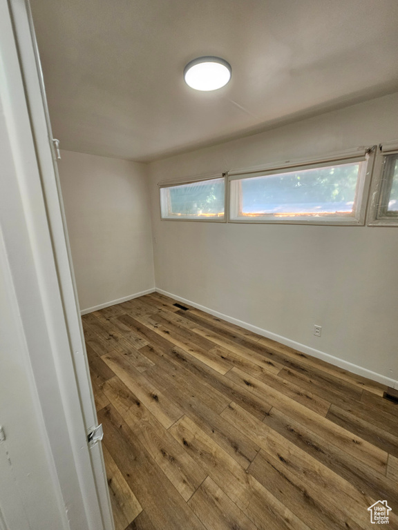 Spare room with hardwood / wood-style flooring and baseboards